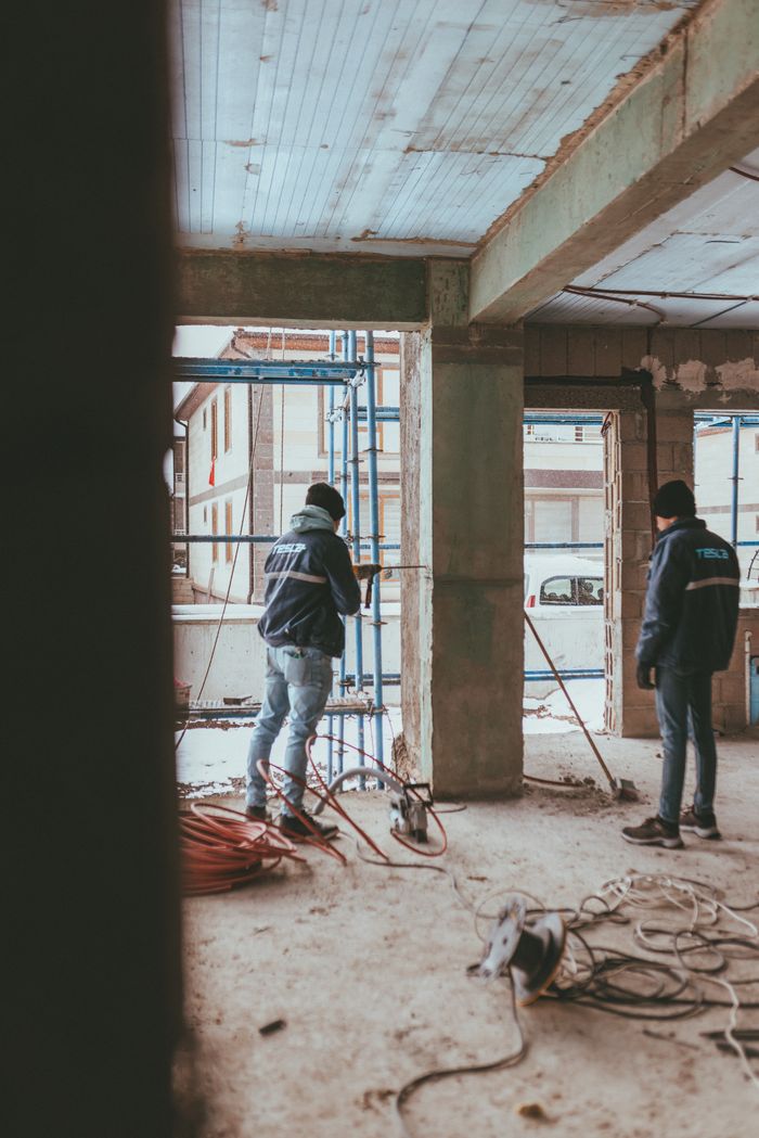Construction workers in a partially built structure, showcasing teamwork.
